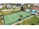 Community tennis court with green surface and surrounding fence at 3370 Ocean Shore Blvd # 203B, Ormond Beach, FL 32176