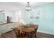 Charming dining area with rustic wooden table and chairs, light blue walls, and kitchen view at 3370 Ocean Shore Blvd # 203B, Ormond Beach, FL 32176