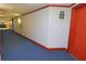 Condo hallway with blue carpet and red doors at 231 Riverside Dr # 2409-1, Holly Hill, FL 32117