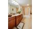 Bathroom with granite countertop, wood cabinets, and a bathtub at 3801 S Atlantic Ave # 303, Daytona Beach Shores, FL 32118