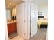 Clean bathroom with a single sink vanity and access to bedroom at 231 Riverside Dr # 1106-1, Holly Hill, FL 32117
