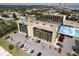 Aerial view of condo building, pool, tennis courts, and parking lot at 1433 N Atlantic Ave # 422, Daytona Beach, FL 32118
