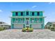 Two-story teal home with a three-car garage and paver driveway at 4711 S Atlantic Ave, Ponce Inlet, FL 32127