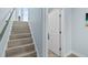 Modern staircase with light wood-look laminate treads and metallic handrail at 4711 S Atlantic Ave, Ponce Inlet, FL 32127