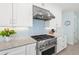 Modern kitchen features stainless steel range, light blue backsplash, and white cabinets at 4711 S Atlantic Ave, Ponce Inlet, FL 32127