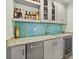 Stylish wet bar with turquoise tile backsplash and ample storage at 4711 S Atlantic Ave, Ponce Inlet, FL 32127