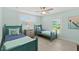Light teal bedroom with twin beds, window shutters, and wood-look floors at 4711 S Atlantic Ave, Ponce Inlet, FL 32127