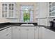 White kitchen with granite countertops and a window over the sink at 2 King Phillips Way, Ormond Beach, FL 32174