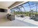 Outdoor kitchen with built-in grill and seating area under a screened lanai at 225 Sunset Point Dr, Ormond Beach, FL 32174