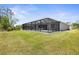 Expansive backyard featuring a large screened lanai and lush greenery at 225 Sunset Point Dr, Ormond Beach, FL 32174