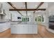 Gourmet kitchen boasts expansive island, stainless steel appliances, and white cabinetry at 12245 Park Ave, Windermere, FL 34786