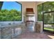 Stainless steel grill and granite countertop outdoor kitchen at 12245 Park Ave, Windermere, FL 34786
