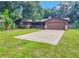Ranch style home with a large driveway and mature landscaping at 1119 Indigo Rd, Ormond Beach, FL 32174