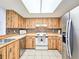 Full kitchen with wood cabinets, tiled floors, and stainless steel appliances at 2600 Ocean Shore Blvd # 3060, Ormond Beach, FL 32176