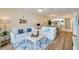 Living room features white couches, hardwood floors, and views of dining area at 4525 S Atlantic Ave # 1502, Port Orange, FL 32127