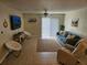 Living room with teal sofa, recliner, and sliding glass doors to patio at 1510 Ocean Shore Blvd # 4140, Ormond Beach, FL 32176