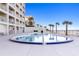 Oceanfront community pool with lounge chairs and beach access at 89 S Atlantic Ave # 1002, Ormond Beach, FL 32176