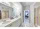 Double vanity bathroom with a view into bedroom and walk-in shower at 424 Luna Bella Ln # 222, New Smyrna Beach, FL 32168