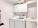 Clean laundry room with cabinets, washer and dryer, and utility sink at 424 Luna Bella Ln # 222, New Smyrna Beach, FL 32168