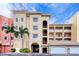 Building exterior with parking and palm trees at 424 Luna Bella Ln # 222, New Smyrna Beach, FL 32168