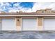 Three-car garage with white doors and exterior lighting at 424 Luna Bella Ln # 222, New Smyrna Beach, FL 32168
