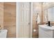 Small bathroom with wood-paneled walls and modern vanity at 1510 Ocean Shore Blvd # 3150, Ormond Beach, FL 32176