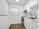 White kitchen features stainless steel appliances and wood-look flooring at 1510 Ocean Shore Blvd # 3150, Ormond Beach, FL 32176