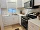 Modern kitchen with stainless steel appliances and white cabinets at 216 Rue De Paresse, Tavares, FL 32778