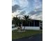 Single-wide mobile home with screened porch and palm trees at 216 Rue De Paresse, Tavares, FL 32778