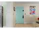Light teal door entryway with decorative panels and beach themed artwork at 1415 Ocean Shore Blvd # B030, Ormond Beach, FL 32176