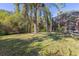 Large backyard with mature trees and screened patio at 3404 Rexford Cir, Ormond Beach, FL 32174