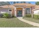 Double front doors with arched entryway and well-manicured landscaping at 3404 Rexford Cir, Ormond Beach, FL 32174