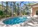 Kidney-shaped pool with a screened enclosure and spa at 3404 Rexford Cir, Ormond Beach, FL 32174