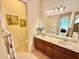 Double vanity bathroom with a large mirror and separate toilet at 708 Aldenham Ln, Ormond Beach, FL 32174