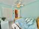 Light blue bedroom with queen bed, ceiling fan, and en-suite bath at 708 Aldenham Ln, Ormond Beach, FL 32174