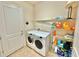 Laundry room with washer, dryer, and shelving unit at 708 Aldenham Ln, Ormond Beach, FL 32174