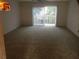 Spacious living room featuring carpet flooring and sliding glass door to balcony at 144 S Halifax Ave # 74, Daytona Beach, FL 32118