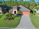 Exterior of the house, showing the driveway and landscaping at 660 Aldenham Ln, Ormond Beach, FL 32174