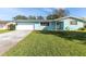 Ranch style home with light blue exterior, white garage door, and manicured lawn at 2329 Oriole Ln, South Daytona, FL 32119