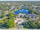 Aerial view showing apartment buildings, lake, pool, and surrounding landscape at 940 Village Trail # 7-107, Port Orange, FL 32127