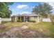 Backyard view of tan house with screened porch and fence at 1300 Benton Lake E Dr, Deland, FL 32724