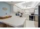 L-shaped kitchen with white cabinets and black appliances at 2294 Ocean Shore Blvd # 1020, Ormond Beach, FL 32176
