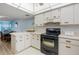 White kitchen with black appliances and a breakfast bar at 2294 Ocean Shore Blvd # 1020, Ormond Beach, FL 32176