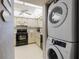 Small kitchen with black appliances and white cabinets at 2294 Ocean Shore Blvd # 1020, Ormond Beach, FL 32176