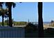 Ocean view from behind a white picket fence, with palm trees and a street sign at 2294 Ocean Shore Blvd # 1020, Ormond Beach, FL 32176