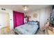 Second bedroom featuring wood-look floors and bold pink curtains at 2727 N Atlantic Ave # 203, Daytona Beach, FL 32118