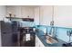Kitchen with dark countertops, black appliances, and light wood cabinets at 2727 N Atlantic Ave # 203, Daytona Beach, FL 32118