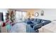 Living area with blue sectional sofa, balcony access, and festive decorations at 2727 N Atlantic Ave # 203, Daytona Beach, FL 32118