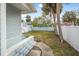 Backyard with palm trees, a white fence, and a concrete walkway at 318 Vermont Ave, Daytona Beach, FL 32118
