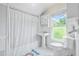 Bright bathroom featuring white fixtures, shower, and checkered tile floor at 318 Vermont Ave, Daytona Beach, FL 32118